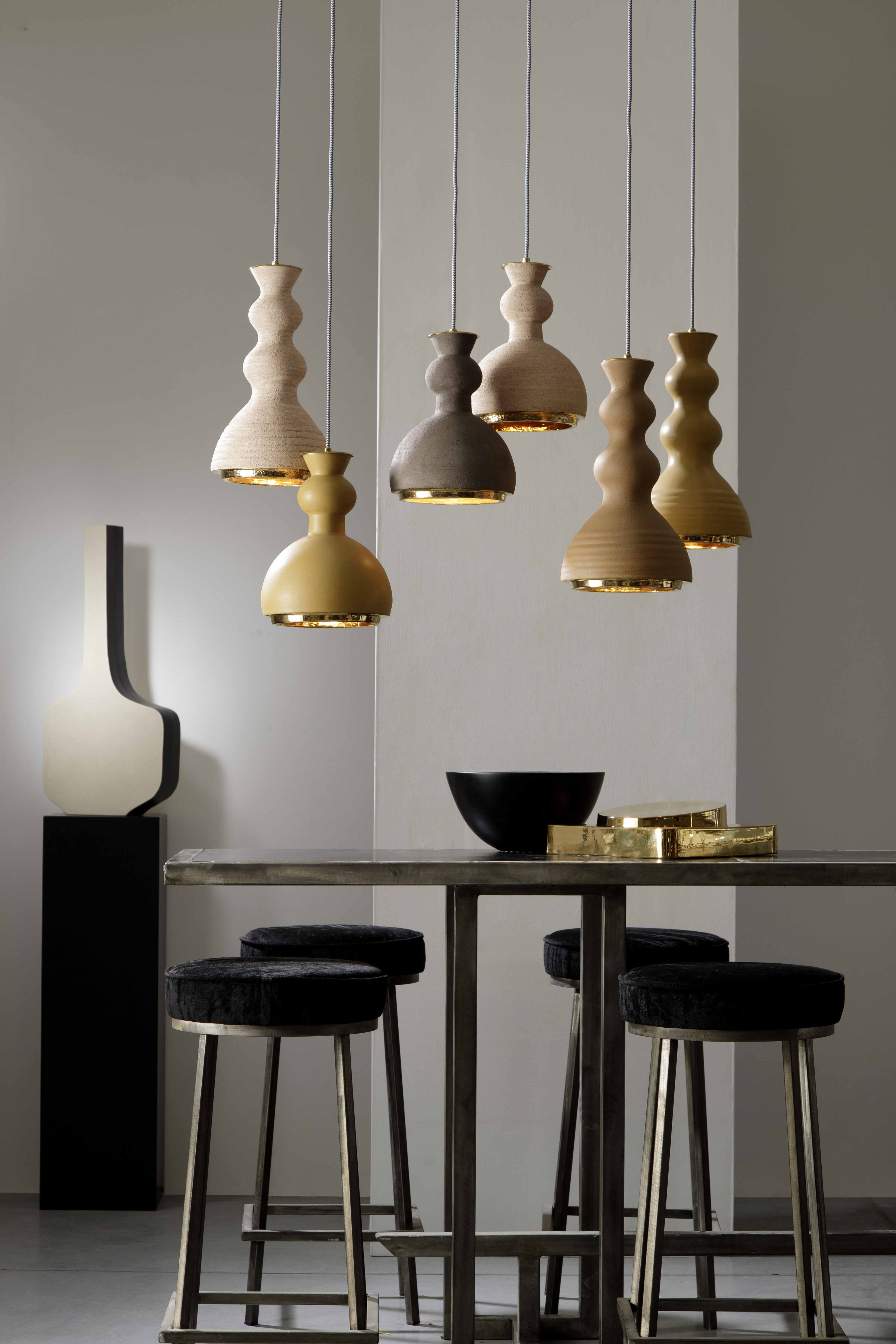 ALLEGRA - Serie di sospensioni in ceramica, colorate con smalti o in terra refrattaria rosata o scura, gli interni sono tutti dorati. In abbinamento; le lampade da tavolo della sua collezione