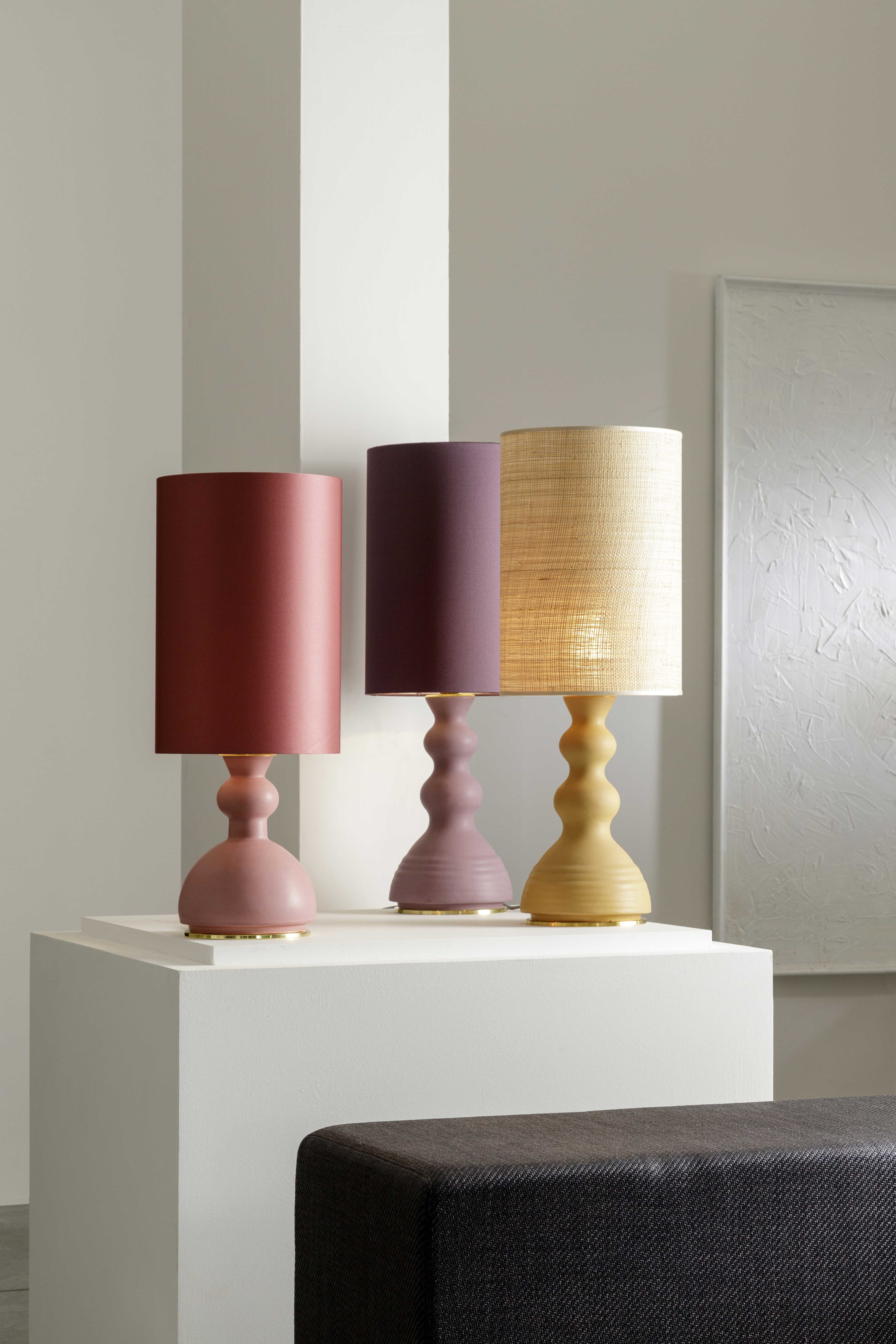 ALLEGRA - Serie di lampade da tavolo in ceramica, colorate con smalti o in terra refrattaria rosata o scura. I paralumi sono in raso colorato o in paglia naturale