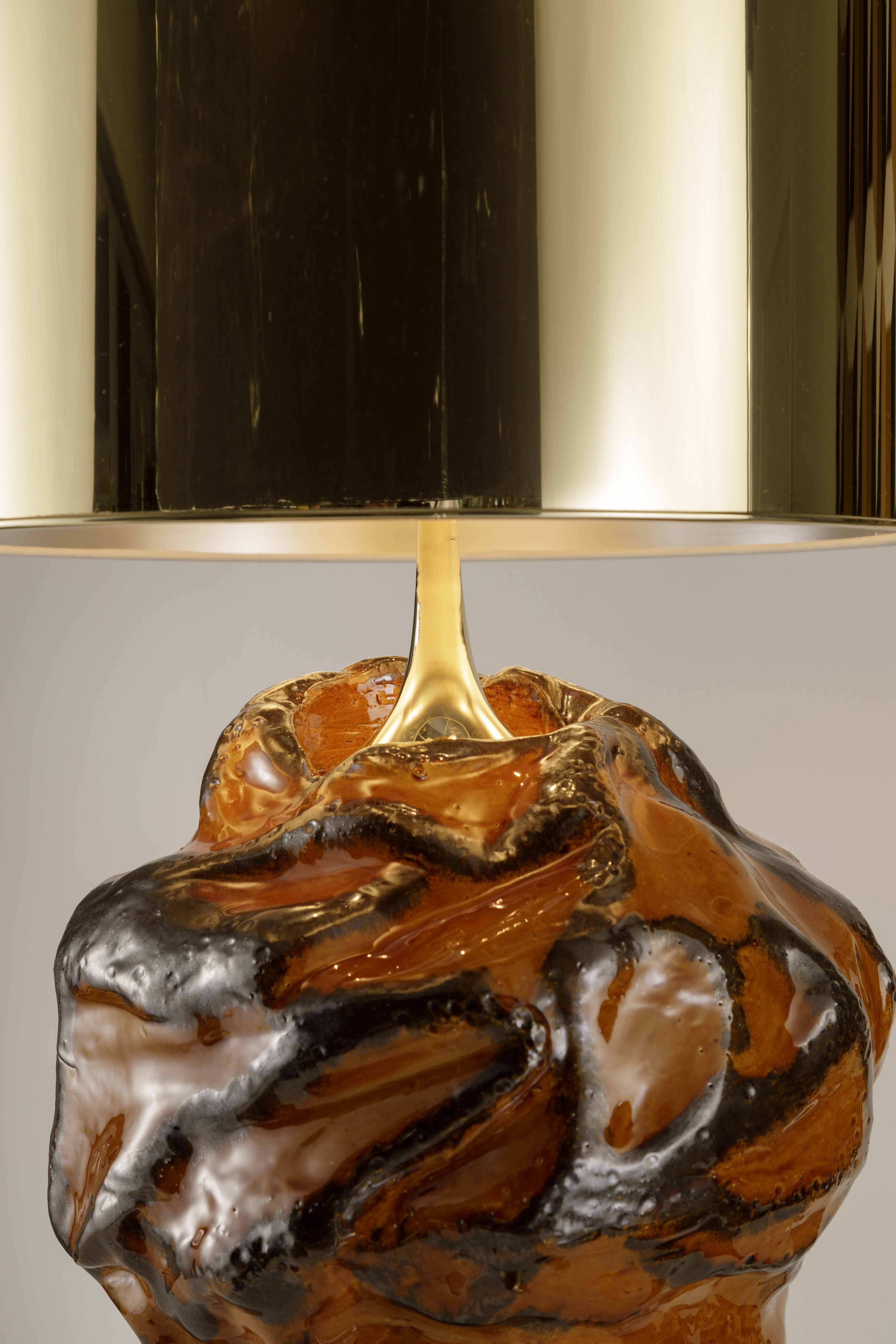 Amber enamel enameled ceramic lamp with bronze mergers in gold. The lampshade is in gold polycarbonate