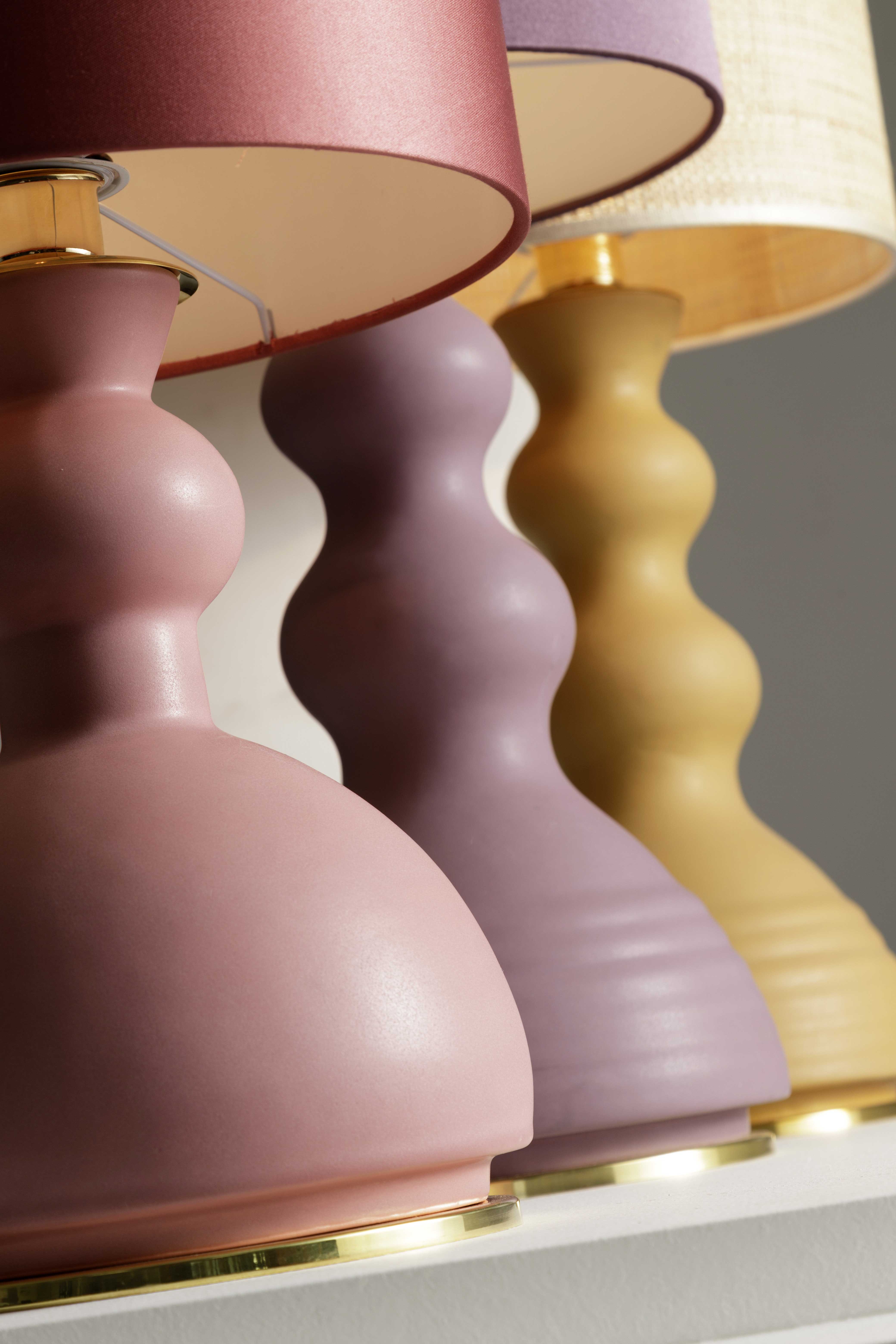 ALLEGRA - Serie di lampade da tavolo in ceramica, colorate con smalti o in terra refrattaria rosata o scura. I paralumi sono in raso colorato o in paglia naturale