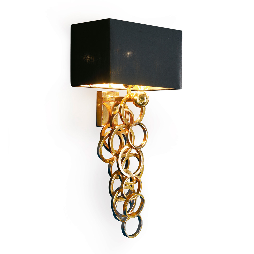 Iron wall lamp with golden, hand soldered rings.
Rectangular black chintz lampshade with golden inside.